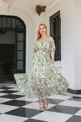 a lady in a green floral printed silk dress